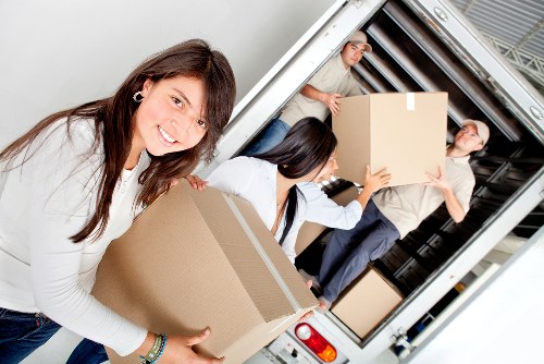 Professional movers carrying household furniture during a local relocation